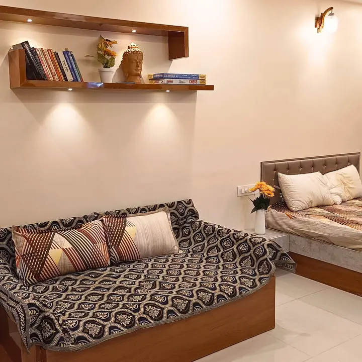Queen bed and sofa bed beneath a lit wooden bookshelf
